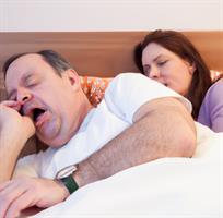 /a-man-in-a-bed-snoring-and-waking-up-his-wife