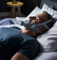 A picture of a person using a CPAP machine to treat sleep apnea